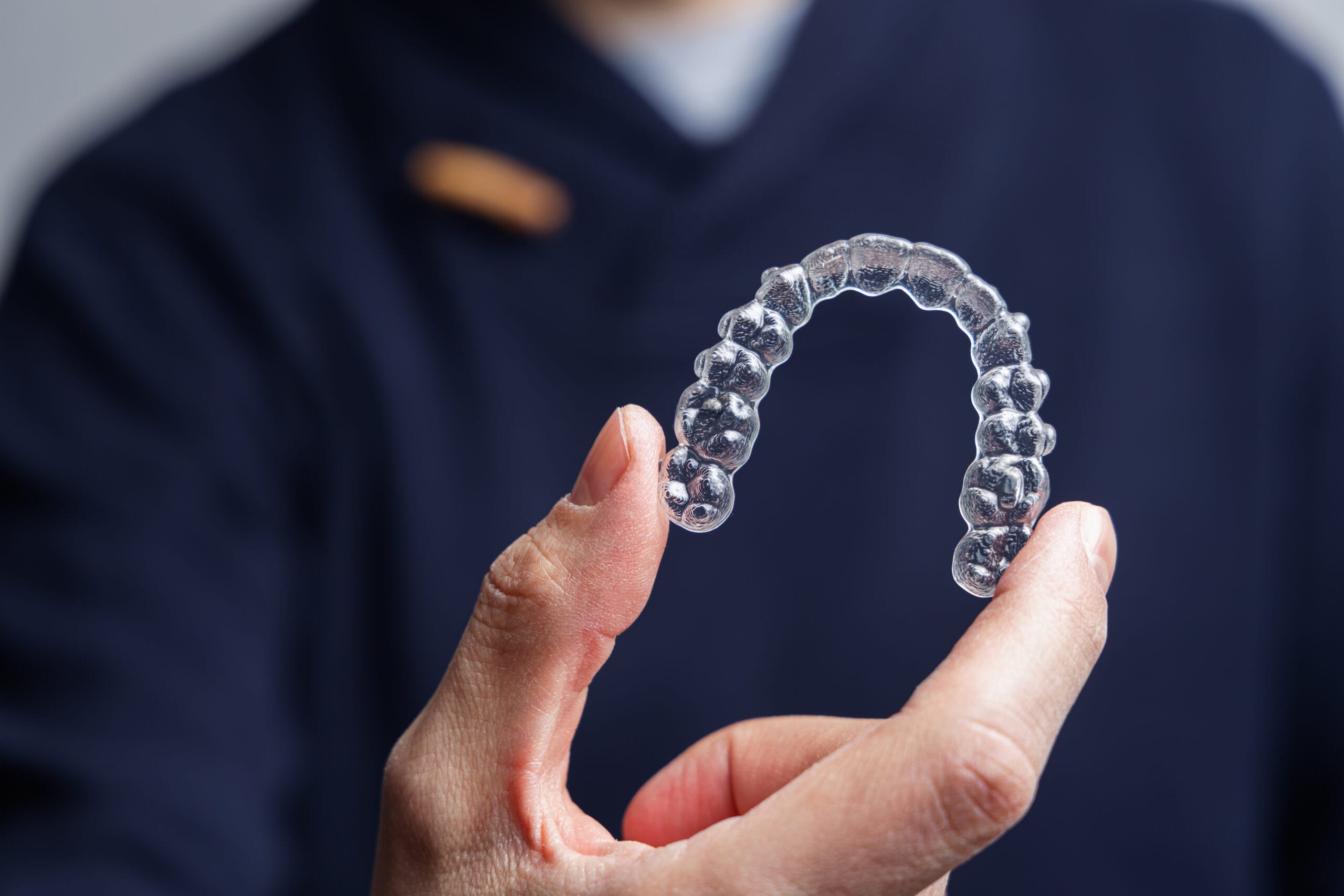 Man holding one transparent aligner. Invisalign orthodontics con Invisalign Sarnia | Dentist Sarnia
